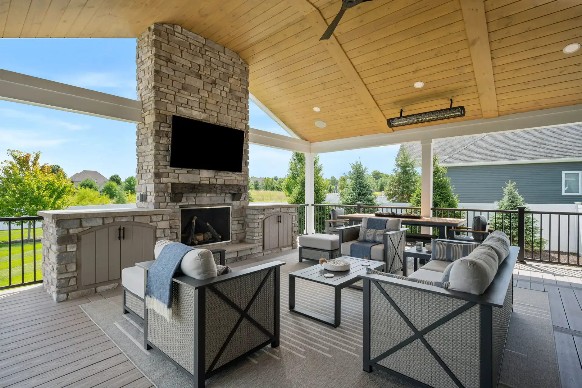 Covered porch with stone fireplace and vaulted wood ceiling in Medina, Ohio by TAB Property Enhancement