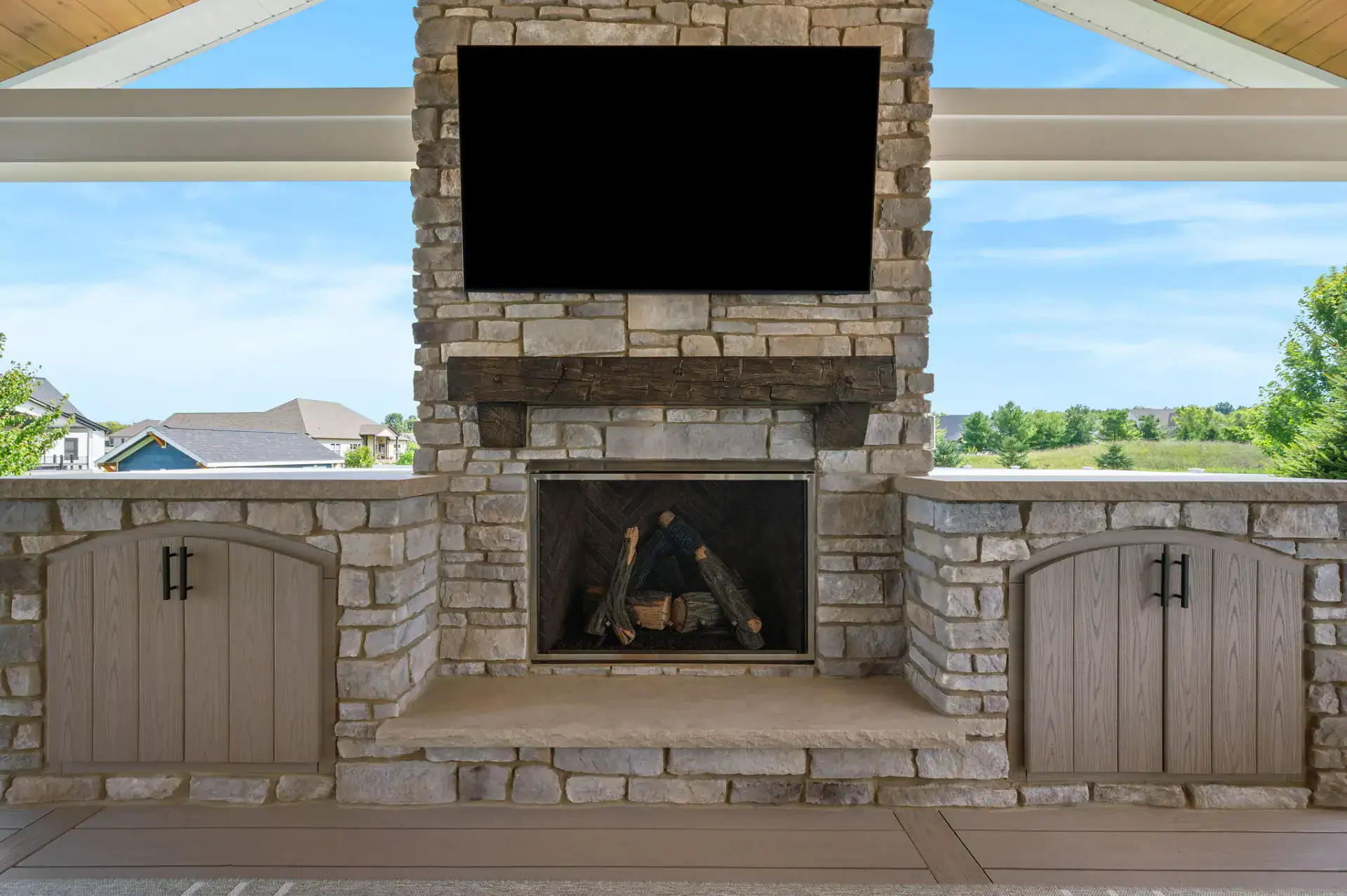 Outdoor stone fireplace with timber mantel and built-in counters in Medina, Ohio by TAB Property Enhancement
