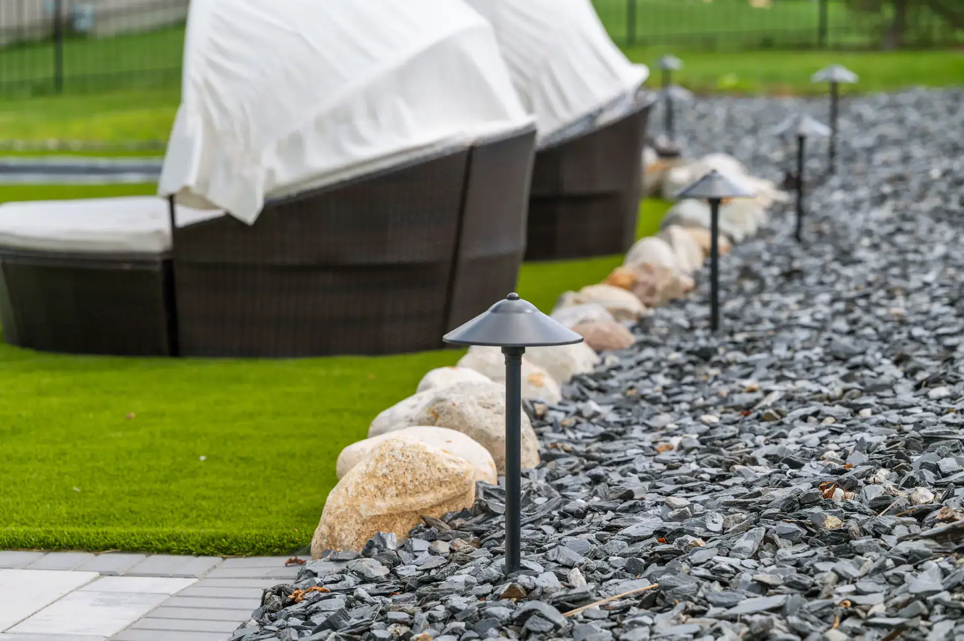 Artificial turf edge with boulder border and low voltage path lighting in Medina, Ohio by TAB Property Enhancement