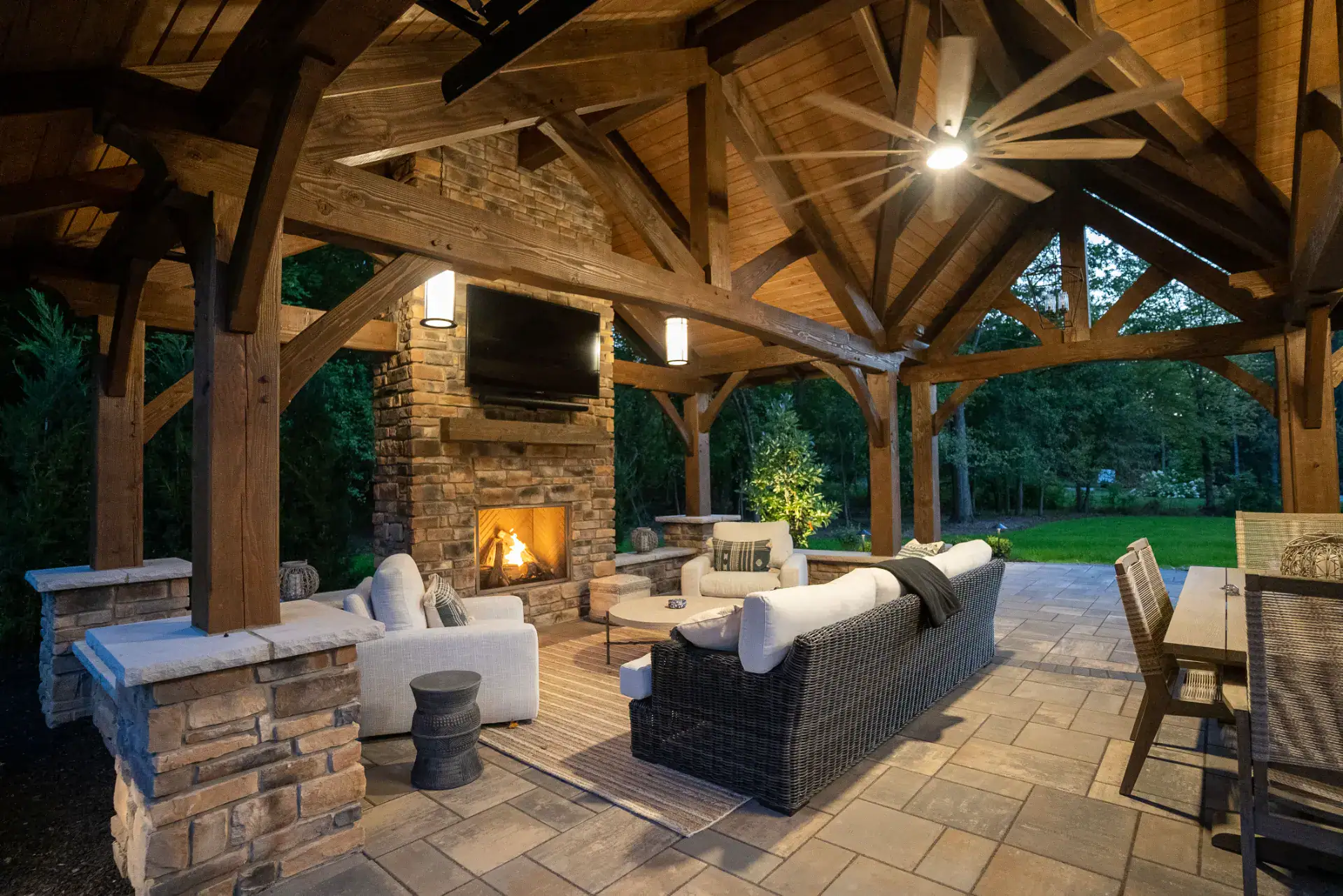 Outdoor stone fireplace with timber mantel under a pavilion in Pepper Pike, Ohio by TAB Property Enhancement