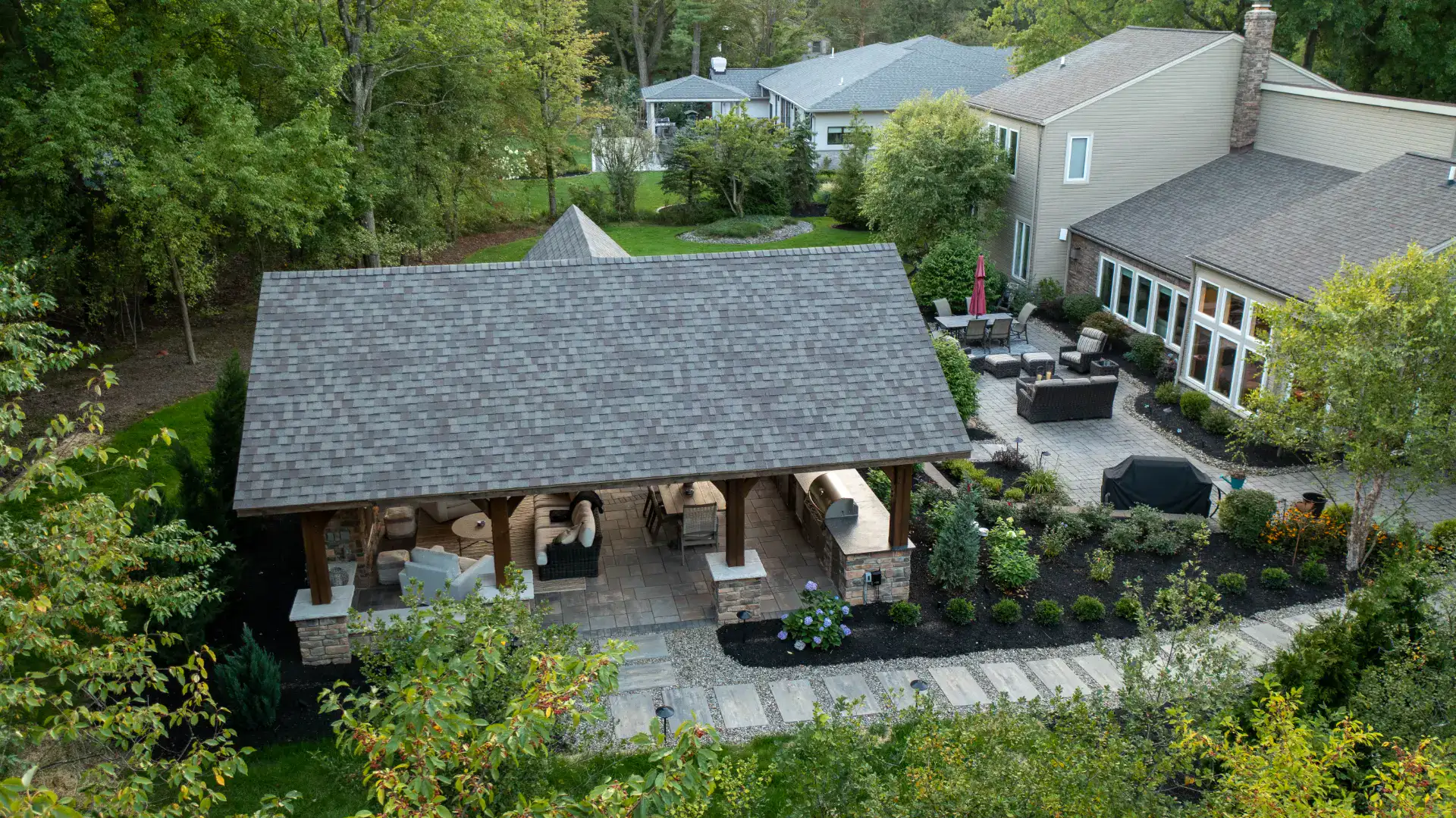 Timber frame pavilion and paver patio behind a home in Pepper Pike, Ohio by TAB Property Enhancement